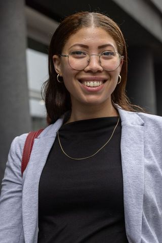 African american professional smiling and standing outside modern office building