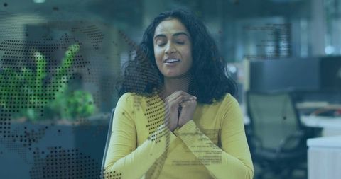 Calm professional woman meditating at glass office desk with digital world map and code overlay