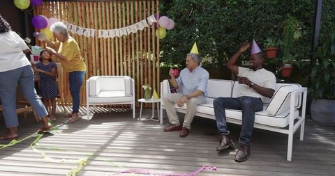 Multigenerational Family Celebrating Birthday on Backyard Deck with Balloons and Decorations