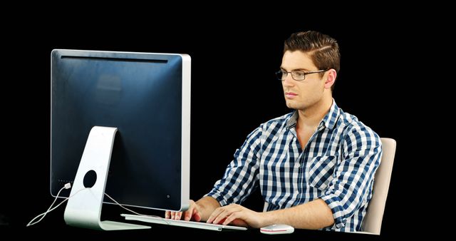 Man working on desktop against black background
