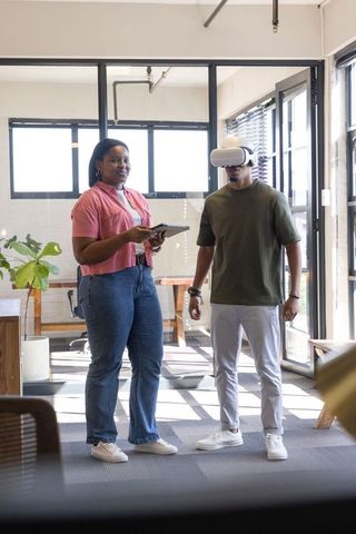 African american coworkers testing vr headset in bright modern office collaboration