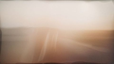 Warm painterly gradient blur with soft horizontal bands and ambient texture