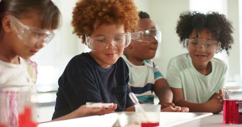 Children exploring science wearing safety goggles in classroom lab