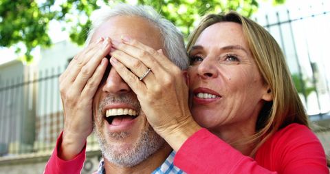 Mature Couple Enjoying a Playful Surprise Outdoors