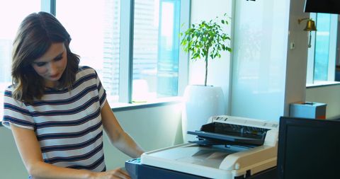 Young Professional Using Photocopier in Modern Office