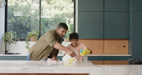 Father and Son Cleaning in Modern Kitchen Having Fun Time