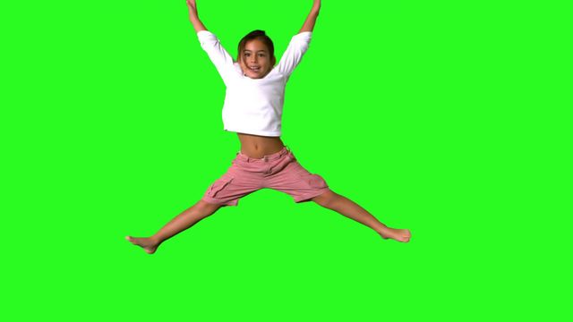 This video captures a young girl jumping with joy against a green screen background, making it perfect for creative projects where the background can be customized. Ideal for use in advertisements, educational content, children's entertainment, and health and wellness promotions.