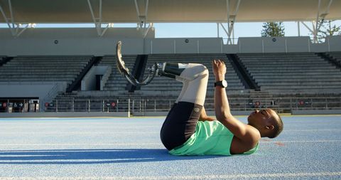 Determined paralympic athlete stretching on track stadium