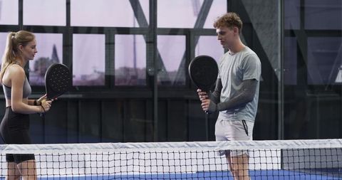 Athletic Duo Engaging in Padel Game, Focusing Techniques