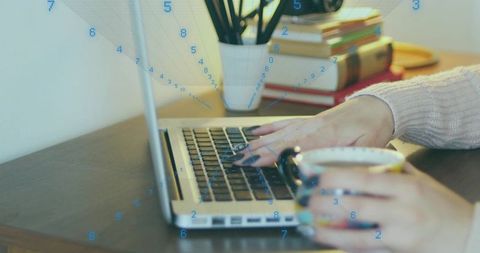 Typing on Laptop at Home Desk with Coffee Cup and Digital Data Overlay