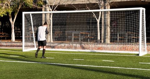 Young Soccer Player Walking Towards Goal Post, Daytime Field Play - Download Free Stock Images Pikwizard.com
