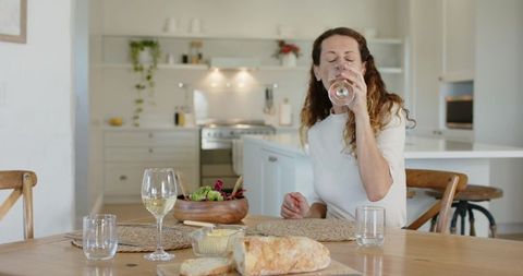 Woman Enjoying Wine in Modern Kitchen with Rustic Bread