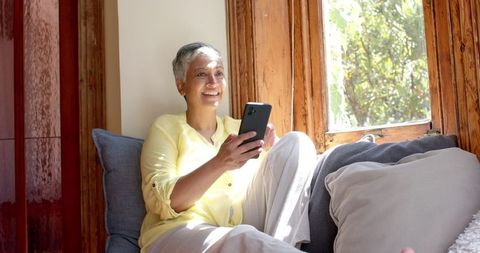Senior Woman Enjoying Smartphone Relaxing on Cozy Couch