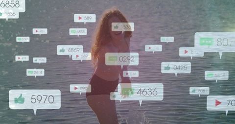 Red-haired woman splashing in shallow ocean surrounded by social media reaction overlays
