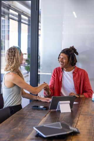 Diverse Team Shaking Hands at Office in a Collaborative Meeting
