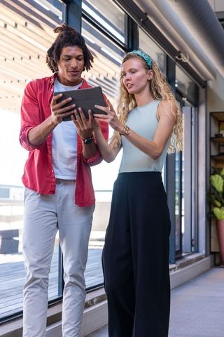 Diverse Office Colleagues Collaborating on Tablet Device by Windows