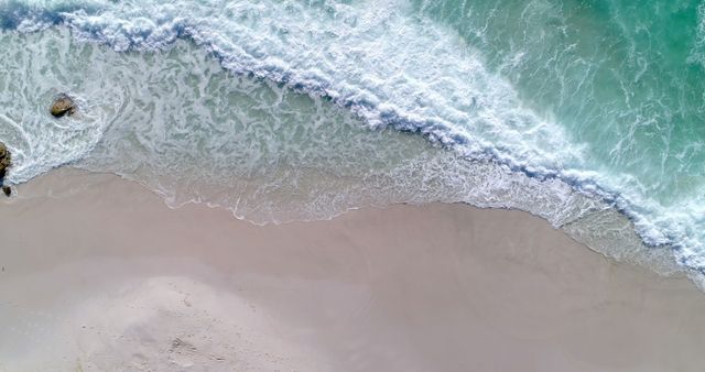 Aerial view of gentle waves washing onto a sandy beach - Download Free Stock Photos Pikwizard.com
