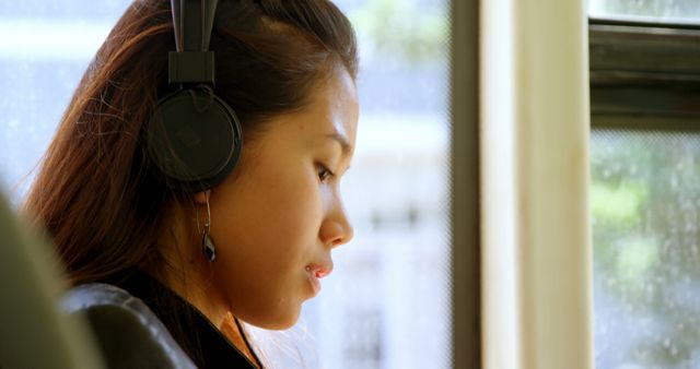 Young Woman Listening to Music on Headphones in Sunlit Room - Download Free Stock Images Pikwizard.com