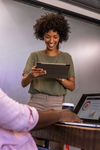 Collaborative team meeting with laptops and digital devices in modern office
