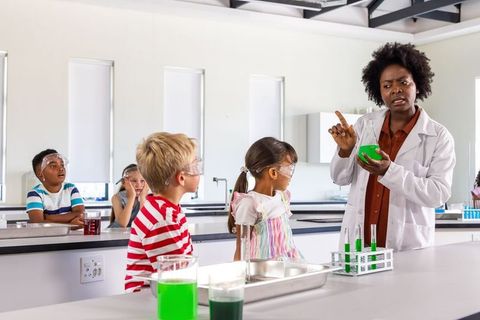 African american teacher demonstrating green chemistry experiment with elementary students
