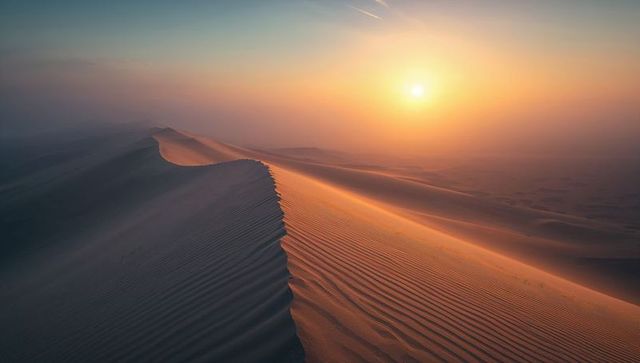 Sweeping sand dunes at sunrise with golden light and contrails