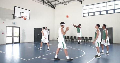 Diverse Male Basketball Team Practicing Jump Shots in Gym