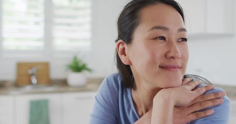 Content Asian Woman Relaxing at Kitchen Table - Download Free Stock Images Pikwizard.com
