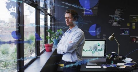 Data analyst gazing out window planning strategy with desktop charts and office greenery