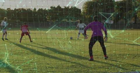 Player Dribbling Soccer Ball Towards Goal at Suburban Sports Field