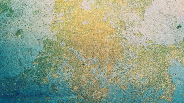 Abstract close-up of a weathered, rusting metal surface with grunge texture and blue and yellow hues. Suitable for backgrounds in graphic design, digital art projects, or creative illustrations.