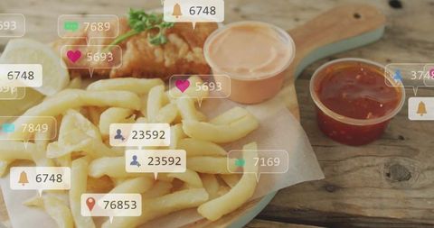 Crispy fish and golden fries on rustic board with dipping sauces and social media icons