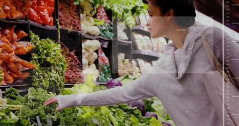 Woman Selecting Leafy Greens in Vibrant Supermarket Produce Aisle