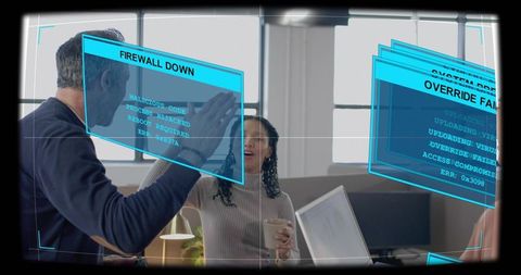 Tech team celebrating cybersecurity win with augmented reality alerts in modern office