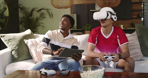 Two friends enjoying virtual reality and gaming session at home