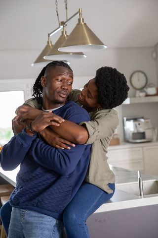 Affectionate couple in modern kitchen embracing