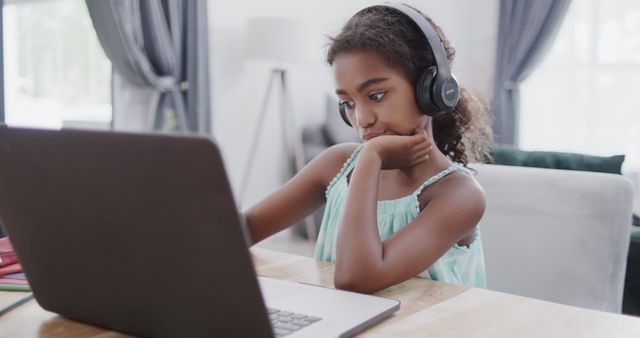 Young girl studying with laptop and headphones in modern home - Download Free Stock Images Pikwizard.com