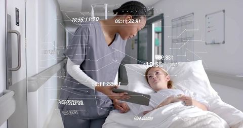 Caring nurse reviewing patient data on digital tablet in hospital ward