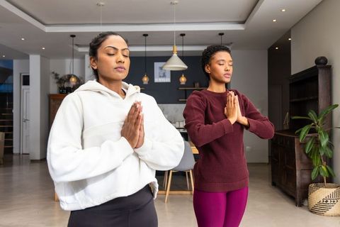 Practicing mindfulness together in modern dining room under pendant lights