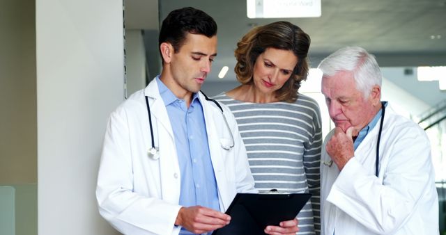 Doctors Discussing Medical Report with Patient in Hospital - Download Free Stock Images Pikwizard.com