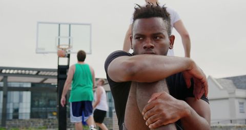 Young Basketball Player Resting On Court Sidelines