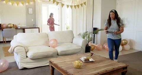 Women Decorate Living Room for Vibrant Birthday Celebration