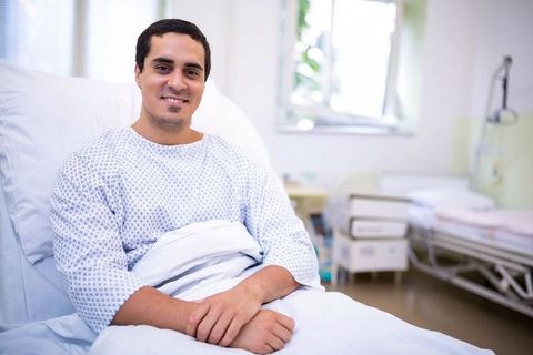 Happy Male Patient Relaxing on Hospital Bed