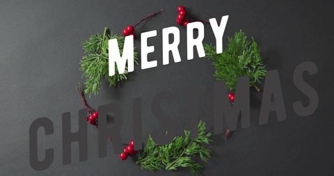 Merry christmas wreath flatlay with evergreen sprigs and red berries on dark background