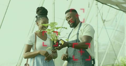 Greenhouse Cooperation: Worker Helps Customer Choose Plant