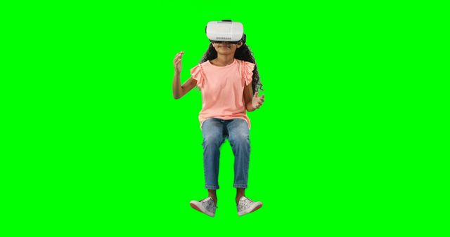 A young African American girl is immersed in a virtual reality experience, seated and wearing a VR headset, with copy space. Her engagement with the technology suggests excitement and curiosity about the digital world.
