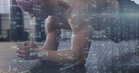 Male athlete holding forearm plank on gym floor with digital data overlay showing focus
