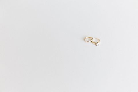 Minimalist gold engagement ring with diamond on white background
