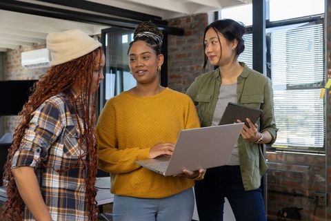 Diverse Female Team Collaborating with Technology in Loft Office