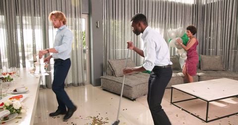 Friends Cleaning Up After Wedding Reception in Living Room