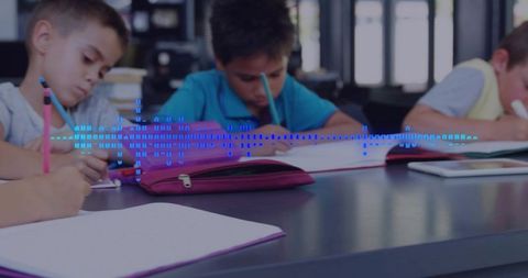 Elementary students writing and focusing with tablet and colorful school supplies